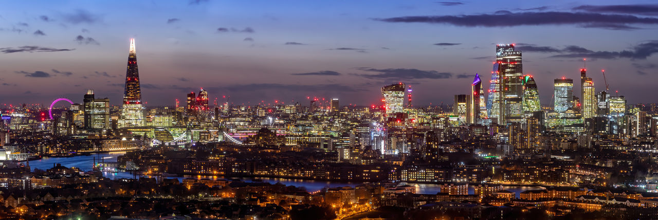 Panoramic view of illuminated buildings against sky at night
