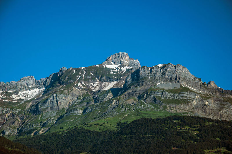Alpine mountain landscape with forests and blue sky, near saint-gervais-les-bains, france.