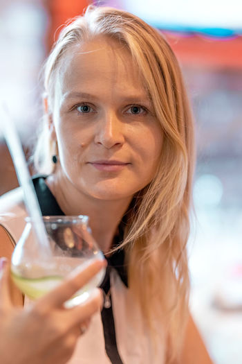 Close-up portrait of a young woman drinking drink