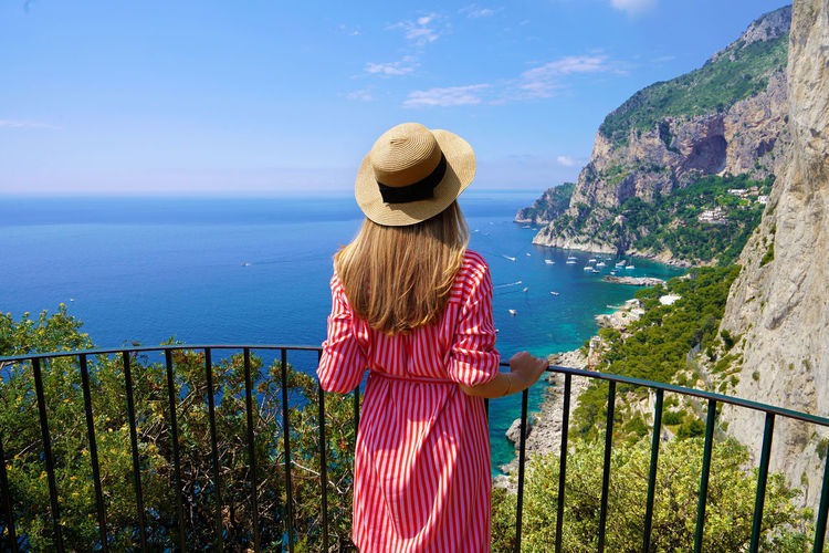 Young beautiful fashion woman enjoying stunning landscape on capri island, italy.