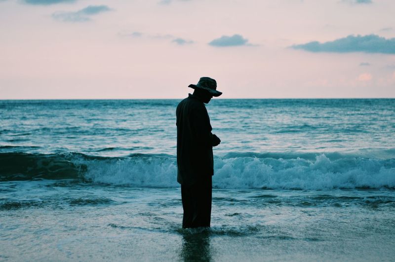 Side view of man standing at beach
