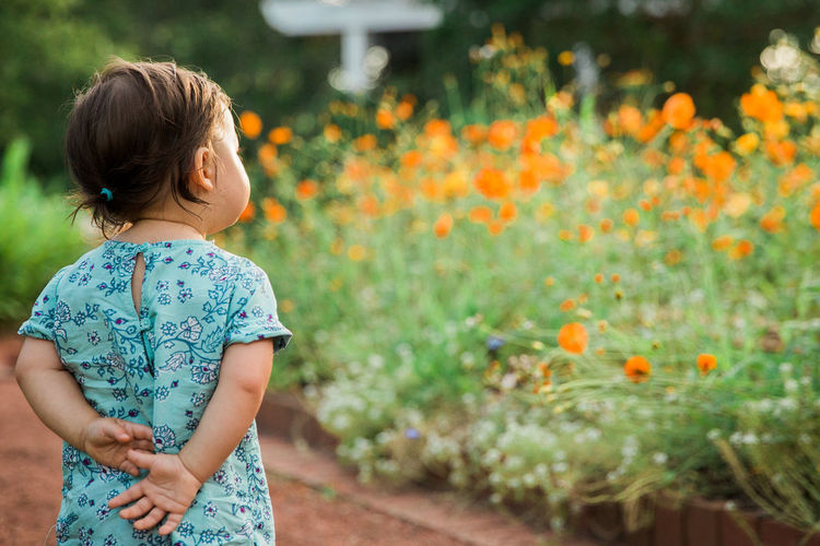 Girl standing against plants