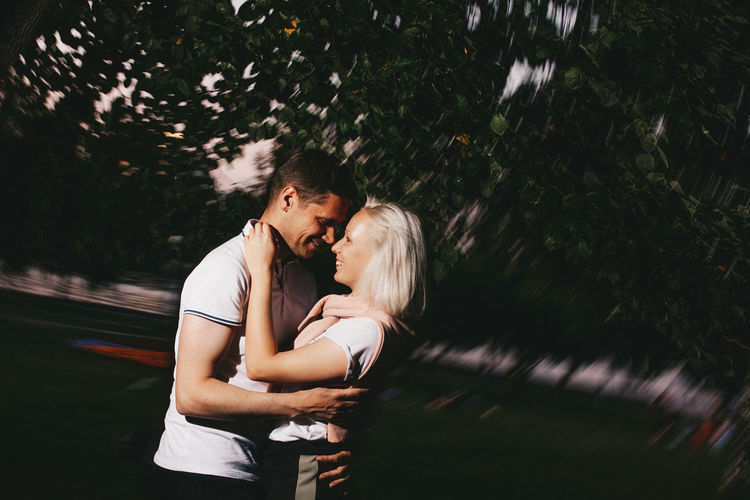 Couple embracing against tree