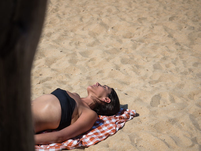 High angle view of woman lying on sand