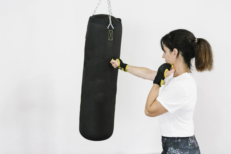 Mature woman training boxing at gym