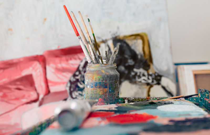 Painter workplace indoor at workshop atelier studio - focus on brushes