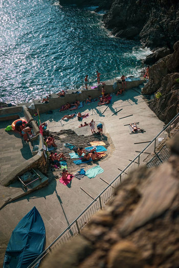 Tourists sunbathing in manarola, italy, europe in 2020
