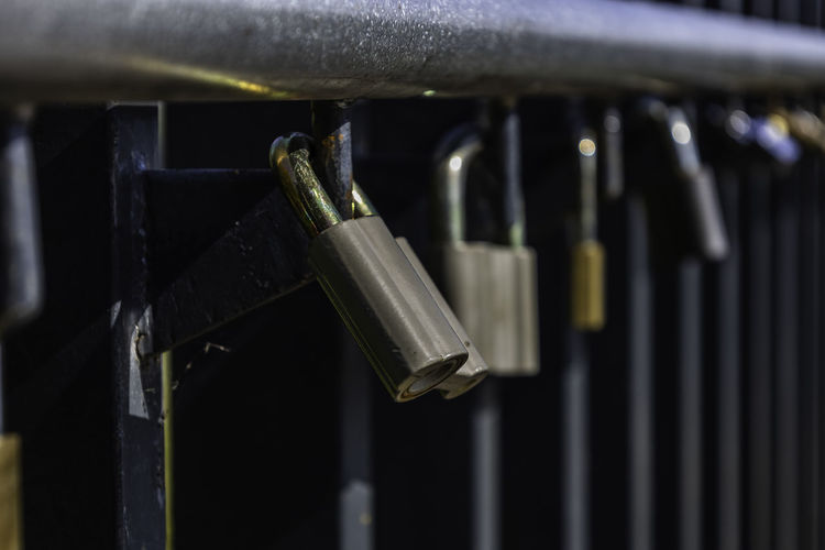 Love locks hanging on the rail among others variegated padlocks