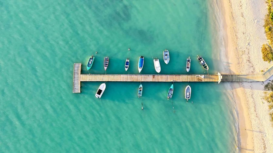 Aerial view of boats moored in sea by pier