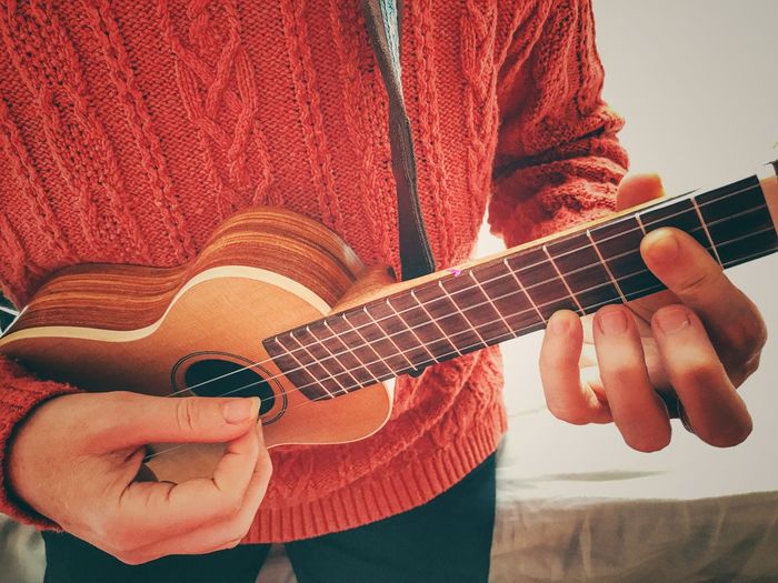Midsection of woman playing ukelele