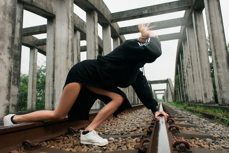 Full length of young woman on railroad tracks