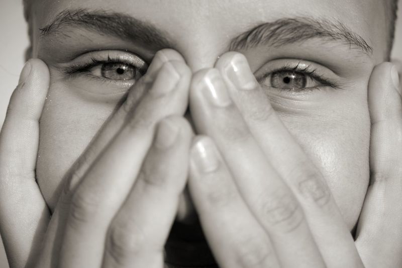Close-up portrait of woman with hands
