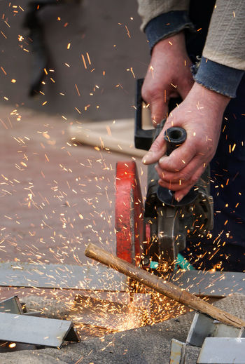 Cropped image of worker cutting metal