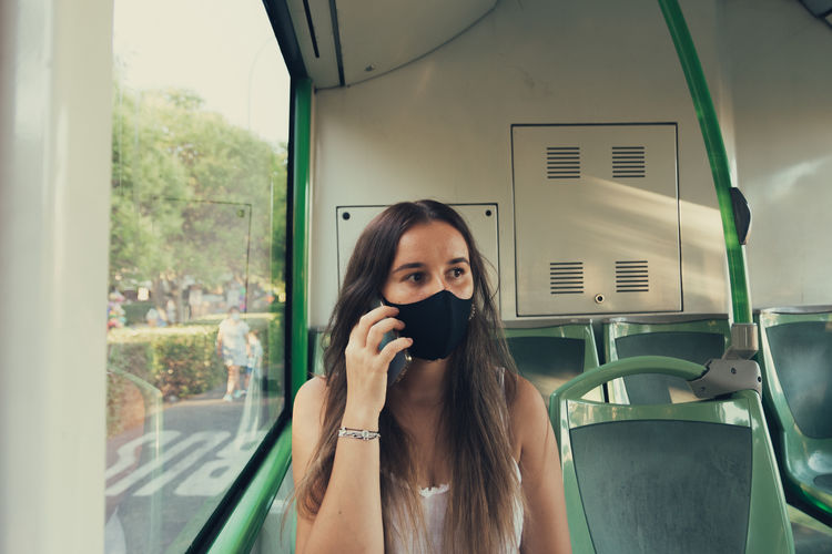 Woman wearing mask sitting in bus