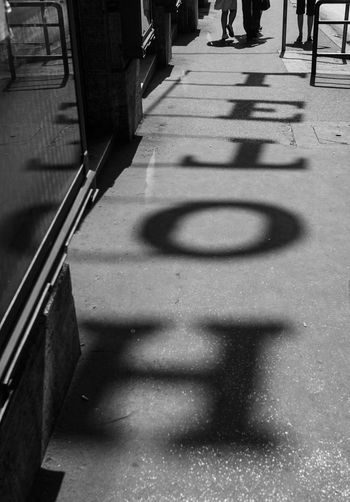 High angle view of alphabet shadow on street