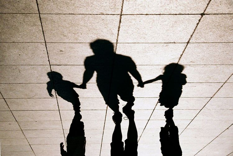 Low section of family walking on tiled floor