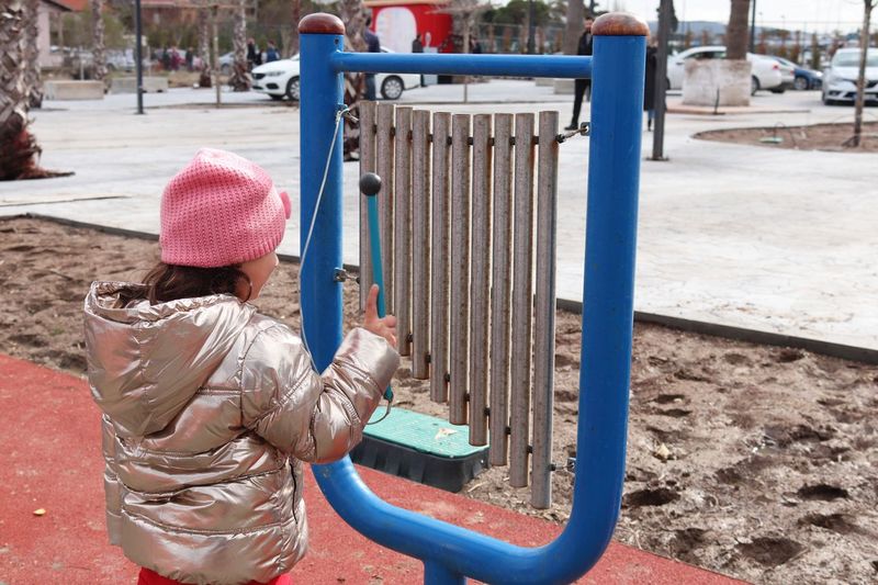 Girl playing large musical instrument at playground