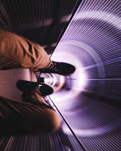 Low section of man on amusement park ride in tunnel