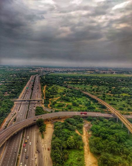 High angle view of bridge in city against cloudy sky
