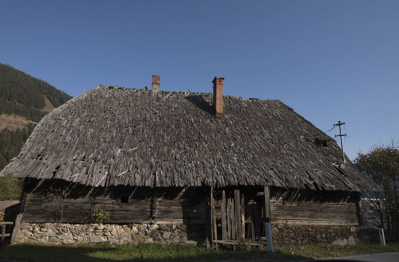 Abandoned alpine wooden hut on a sunny day, clear blue sky