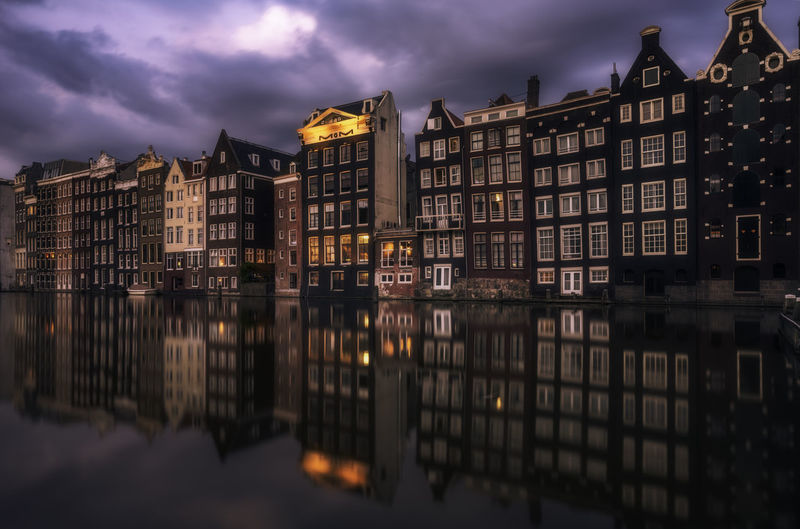 Reflection of buildings in river against sky
