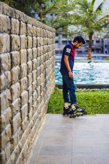 Full length of boy skateboarding on cobblestone