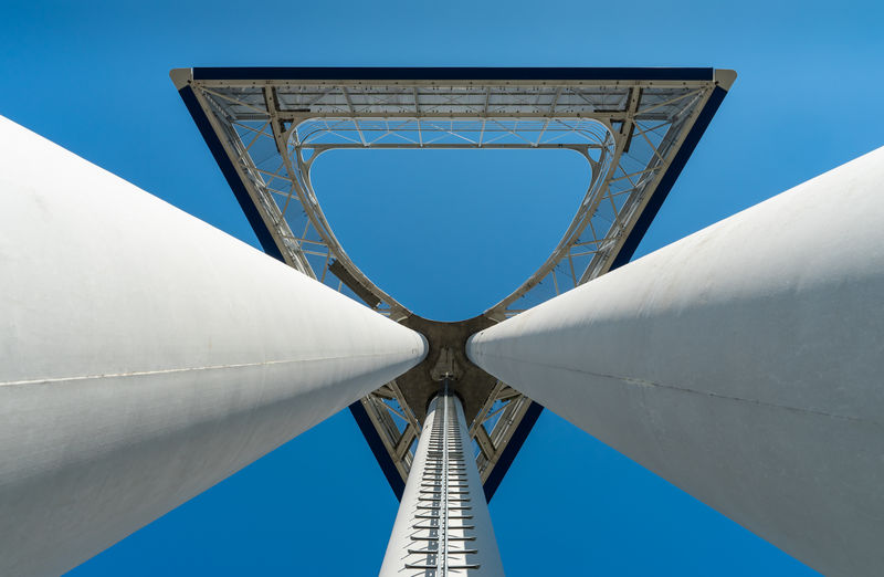 Low angle view of communications tower against clear blue sky