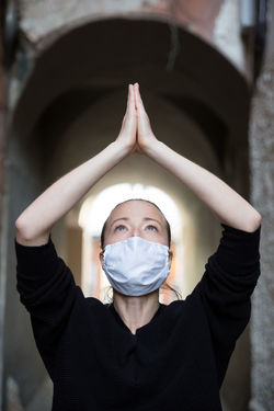 Close-up of woman wearing flu mask meditating outdoors