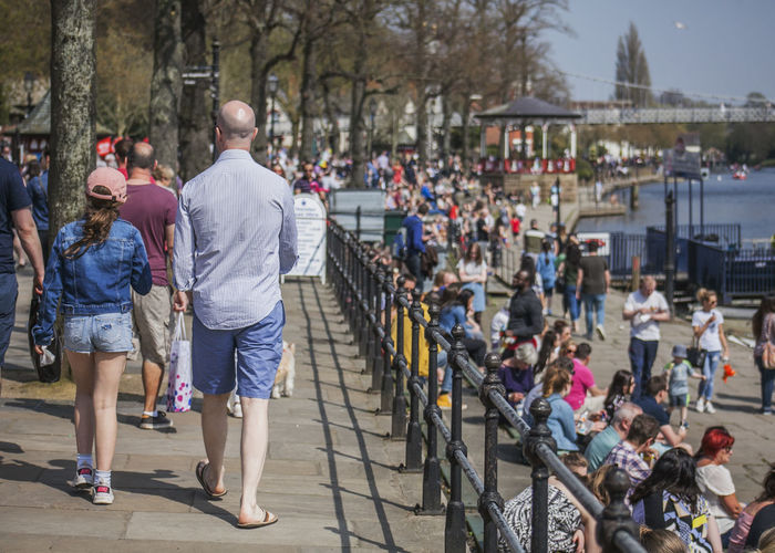 Rear view of people walking on  in city by a river, chester 