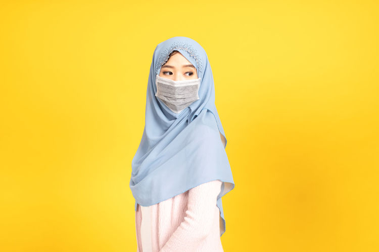 Portrait of a woman against yellow background