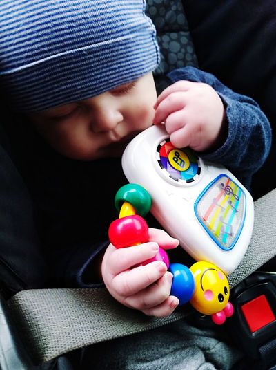 Close-up of baby boy sleeping while sitting in car