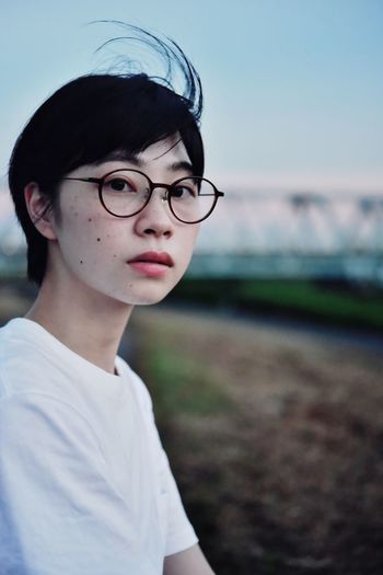 Portrait of woman wearing eyeglasses sitting outdoors