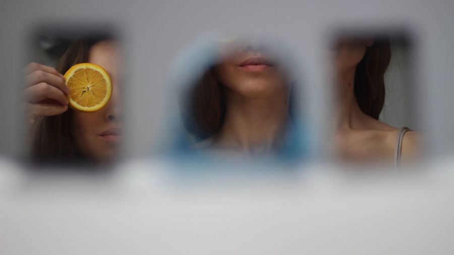 Reflection of woman covering orange slice