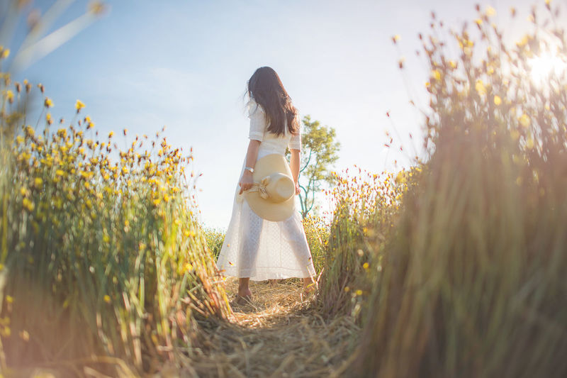Woman standing on field against sky