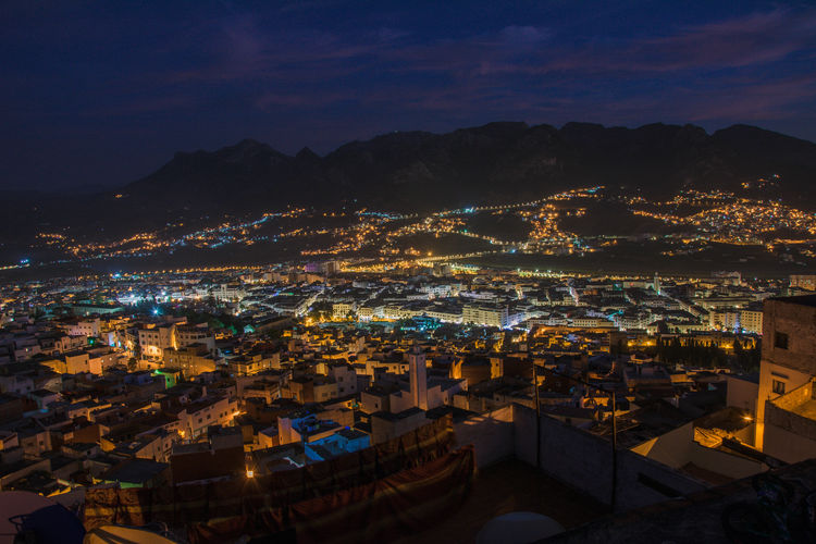 High angle view of illuminated cityscape against sky at night