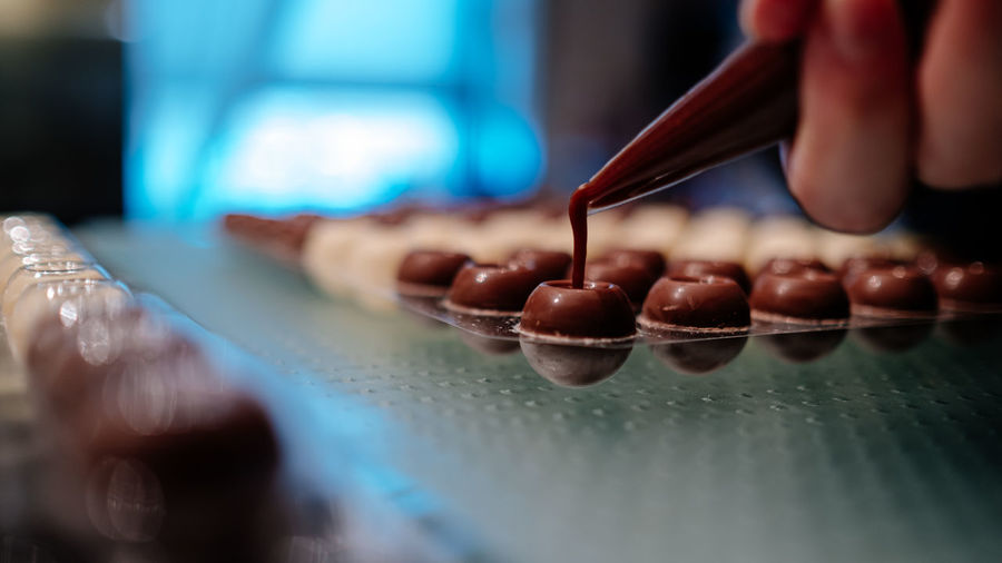 Hand filling pralines with chocolate
