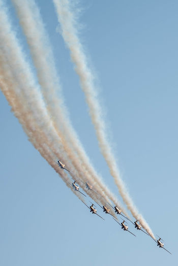 Low angle view of airshow against clear sky