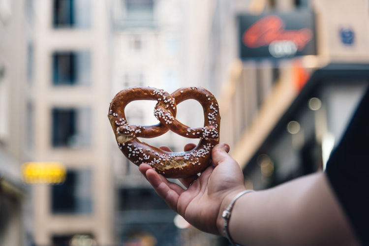 Cropped image of hand holding pretzel