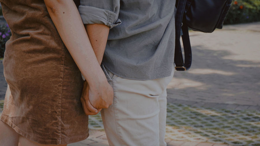 Midsection of couple standing on street