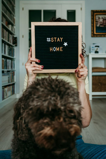 Woman holding slate with stay home text