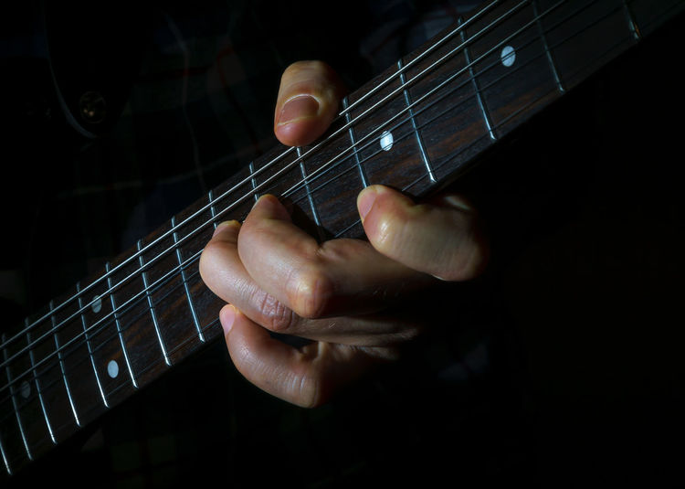 Close-up of hands playing guitar