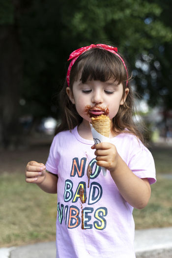 Little girl eating chocolate ice cream witn no bad vibes t-shirt