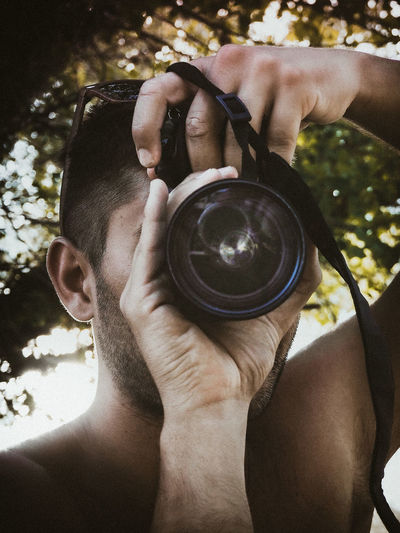 Close-up portrait of man holding camera