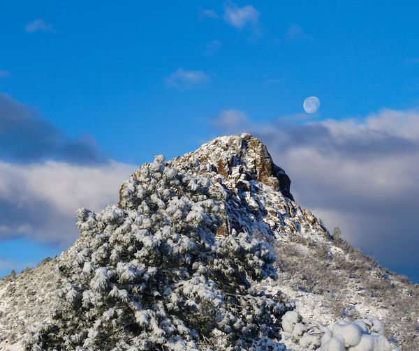 Low angle view of rocks against blue sky
