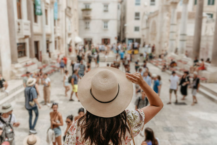 Rear view of woman in sun hat looking over at peristyle at diocletian's palace in split, croatia