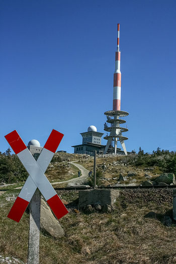 Road sign and tower against clear blue sky at brocken