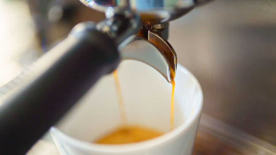Close-up of coffee pouring from faucet