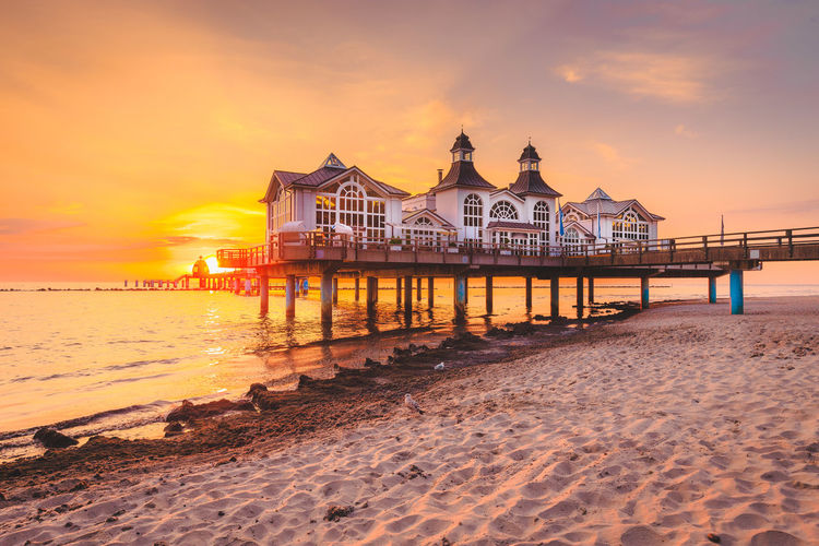Resort at seashore against sky during sunset