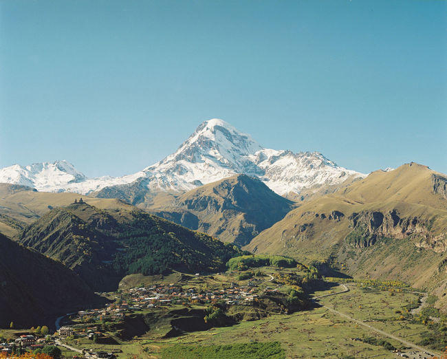 Scenic view of snowcapped mountains against clear blue sky