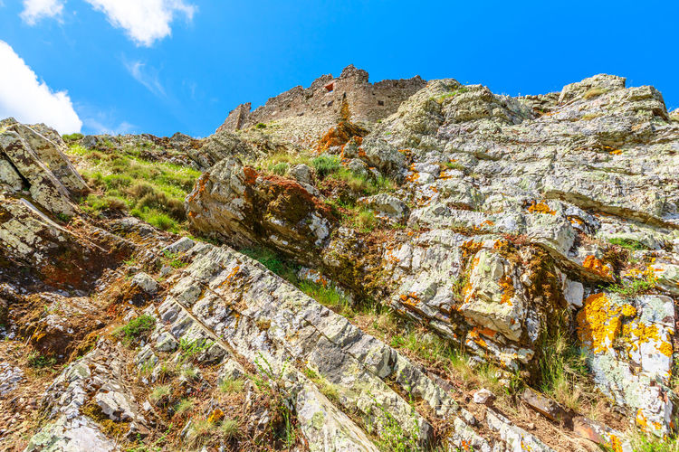 Low angle view of rocks on mountain against sky